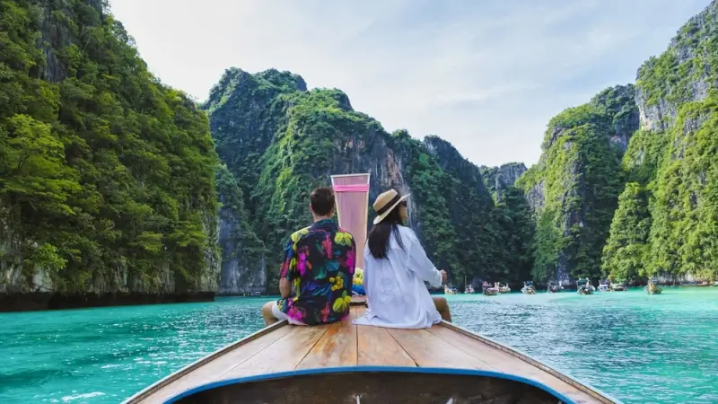 a couplo on a longtail boat at the lagoon of koh phi phi, thailand.
