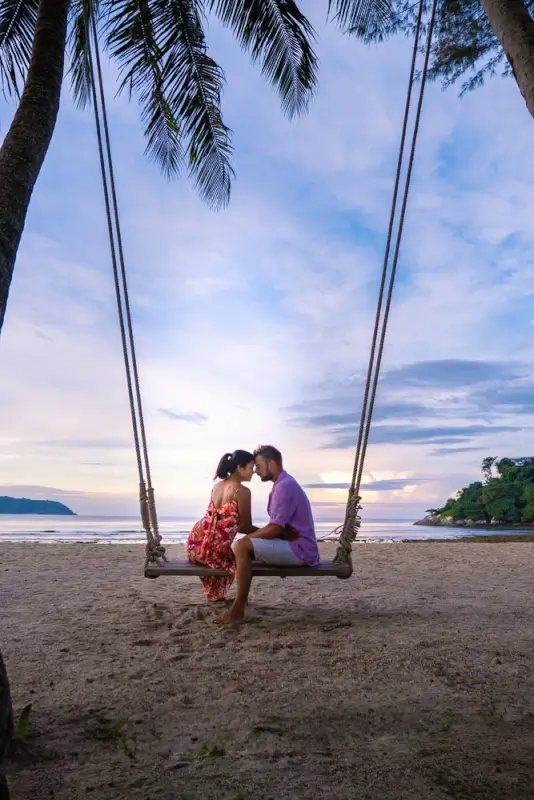 a couple relaxing on the beach in phuket, thailand