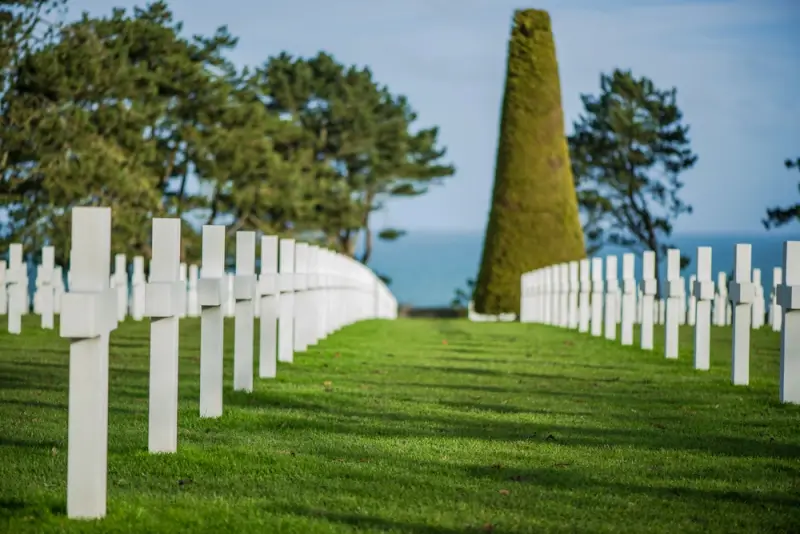 White marble crosses at Normandy American Cemetery with central monument, honoring fallen D-Day soldiers at Omaha Beach