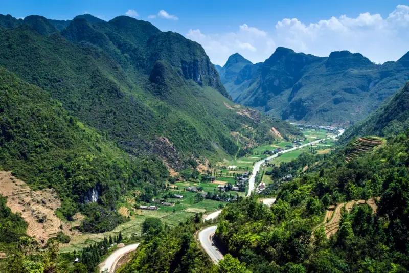 Winding mountain road through limestone karst peaks and valleys on Ha Giang Loop in Dong Van Karst Plateau Geopark Vietnam