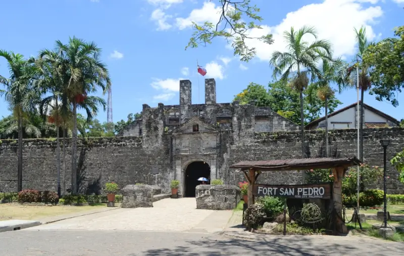 Fort San Pedro entrance with weathered stone walls and Philippine flag, a historic Spanish colonial fortress in Cebu
