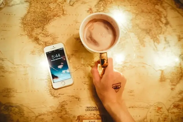Smartphone and coffee cup on world map representing global travel connectivity with eSIM technology