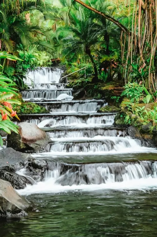 Tabacon Hot Springs natural thermal waterfall cascading through lush rainforest near Arenal Volcano, relaxing stop for Costa Rica travel itinerary