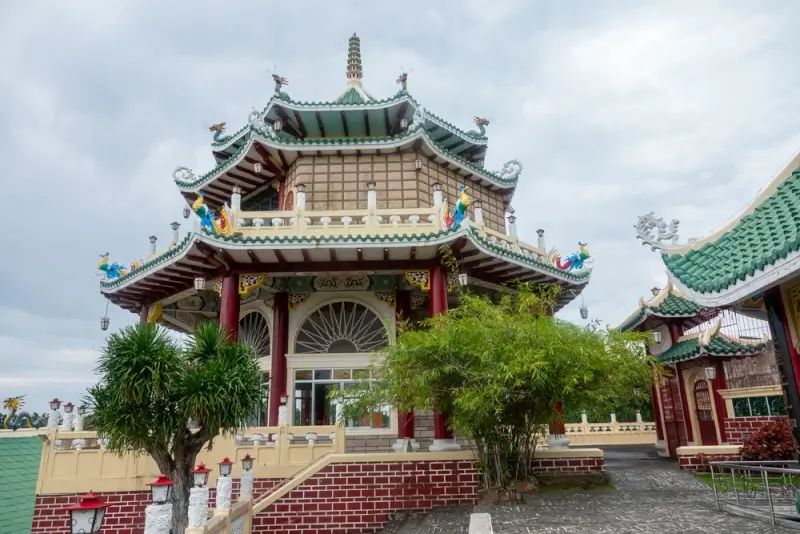 Cebu Taoist Temple with traditional Chinese architecture, curved green roofs, and red pillars in Beverly Hills subdivision