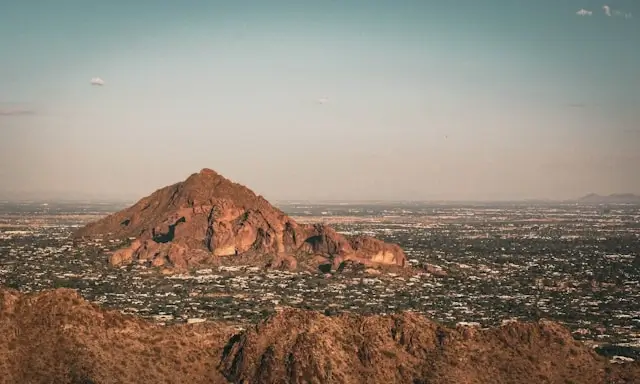 Camelback Mountain rising above residential neighborhoods in phoenix arizona areas with desert landscape and clear sky