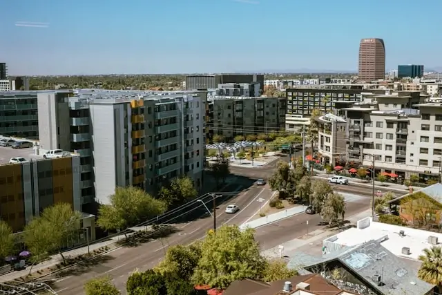 Modern apartment buildings and high-rise towers in downtown Phoenix with palm trees lining urban streets