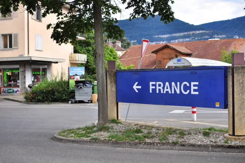 Blue directional road sign pointing to France in a small village near the French border
