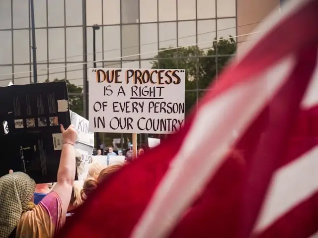 Protesters holding due process rights sign at immigration rally advocating for legal protection for immigrants