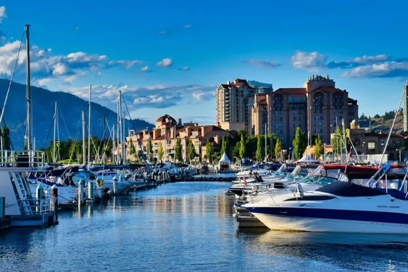 Kelowna marina filled with sailboats and yachts against mountain backdrop showcasing lakeside lifestyle in British Columbia