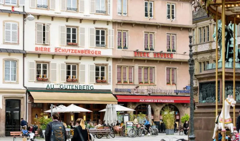 Outdoor café terraces with diners enjoying traditional brasseries in historic Strasbourg city center