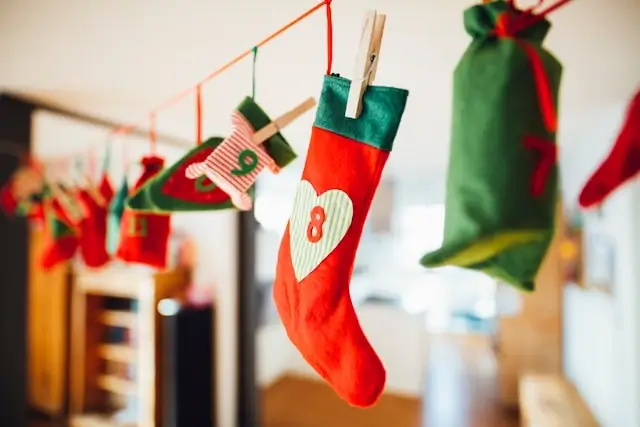 Close-up of colorful Christmas stockings and small gift bags hanging on a string as part of an advent or holiday decoration.
