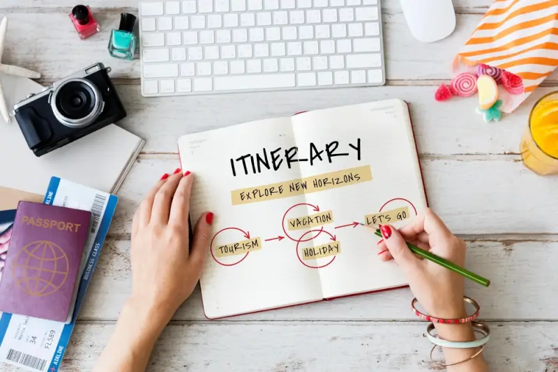 Traveler creating flexible itinerary with notebook, passport, camera, and boarding passes on desk