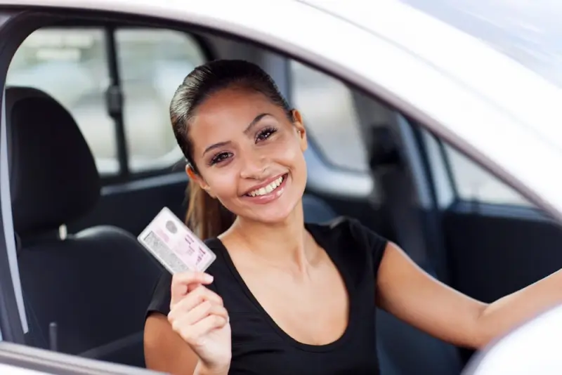 Woman holding valid driving license required for car rental in UAE