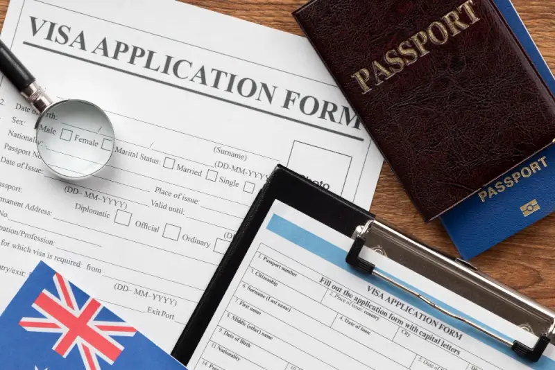 Immigration visa to Australia application form with passport and pen on desk