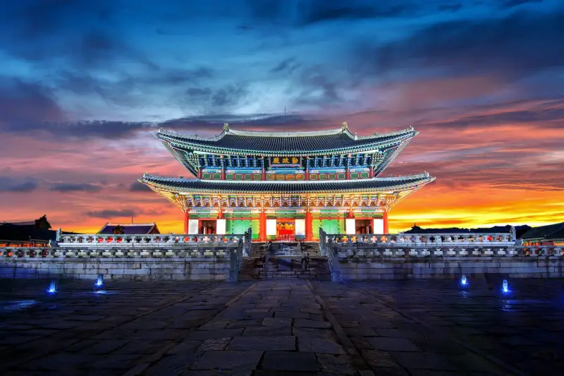 Gyeongbokgung Palace illuminated at sunset with colorful traditional Korean architecture in Seoul