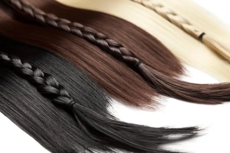 Different types of hair extension bundles displayed in braided sections, showing variations in color, texture, and length for natural hair blending.