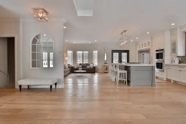 Open-plan home interior with warm wood flooring and neutral tones creating a cohesive, inviting space for gathering and daily living