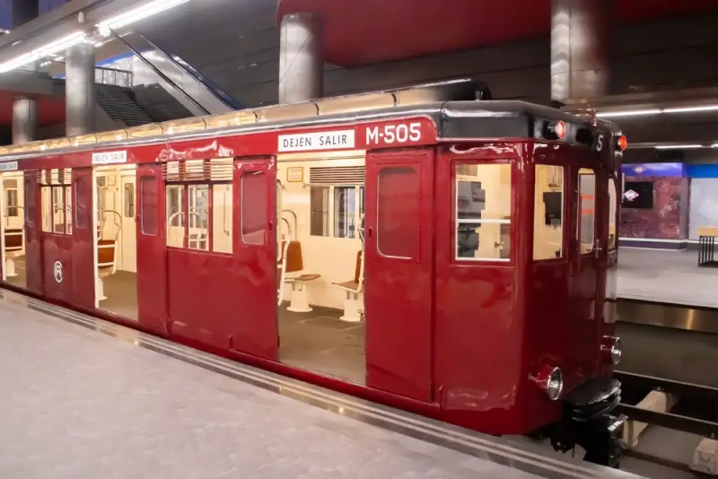 Vintage red Metro car on display at Madrid station, showcasing the city's transport history