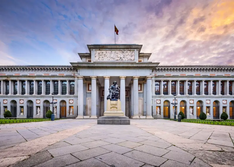 Prado Museum's neoclassical facade at sunset, a must-visit cultural attraction for digital nomads in Madrid