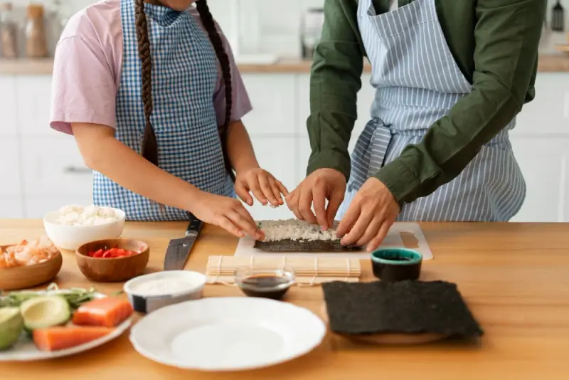 A father and daughter making sushi together in cooking class for memorable experience gift that creates lasting holiday memories