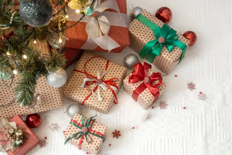 Wrapped holiday presents with colorful ribbons under decorated tree for festive seasonal gift giving ideas