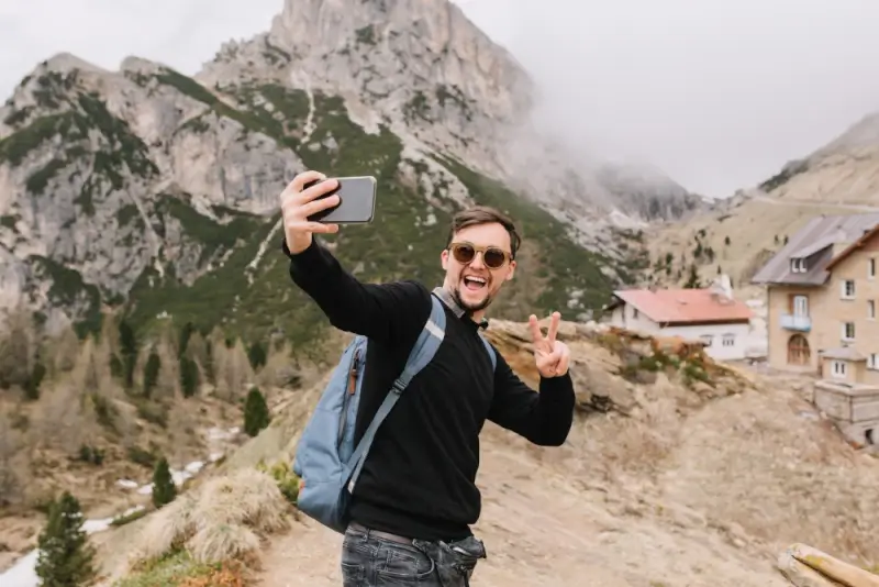 Vlogger recording travel video content in mountain location for repurposing into social media clips