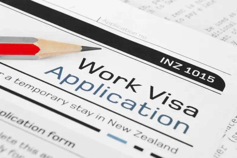 Work visa application form INZ 1015 for temporary stay in New Zealand with red pencil