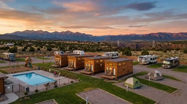 Royal Gorge area luxury RV resort with modern cabins, swimming pool, and mountain views at dusk