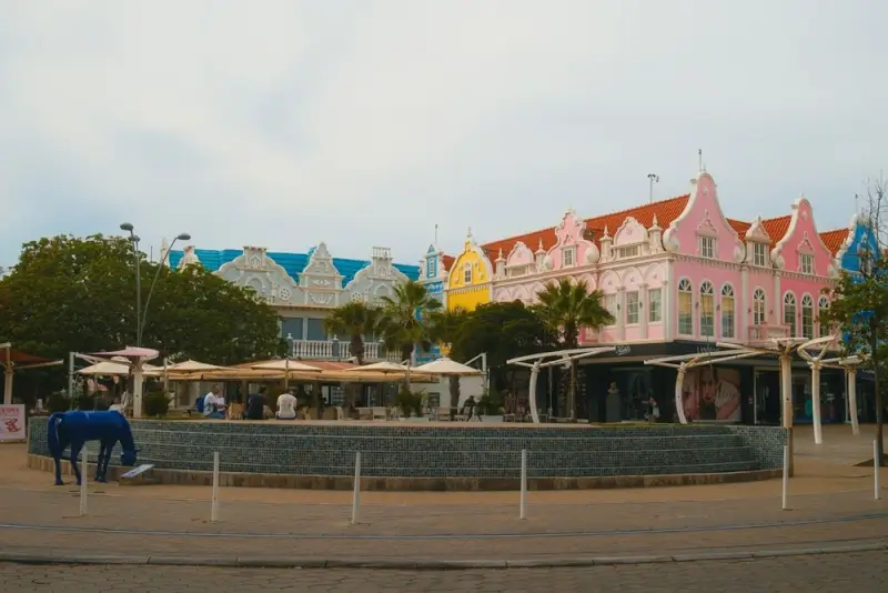 Colorful Dutch colonial buildings with outdoor seating areas in downtown Aruba at dusk