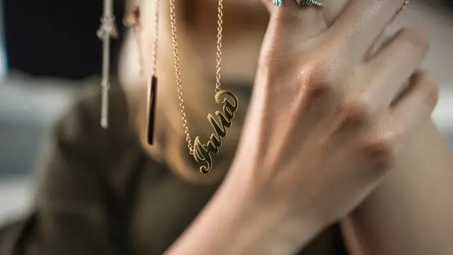 Personalized gold name necklace with Julia script pendant worn on delicate chain