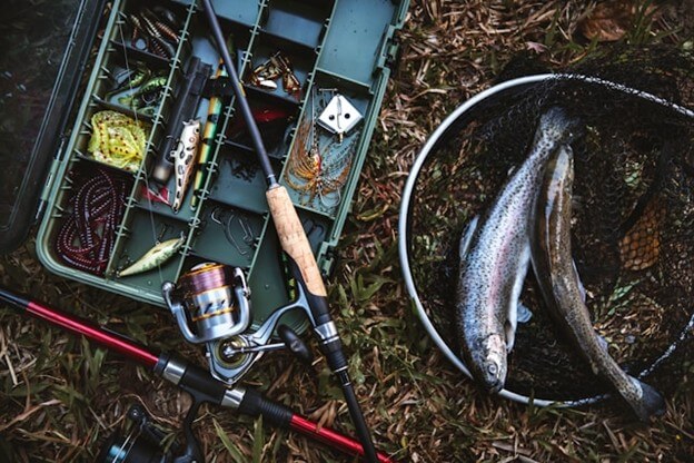 Fishing and glamping near Royal Gorge essentials including tackle box with flies, rod, reel, and fresh caught trout