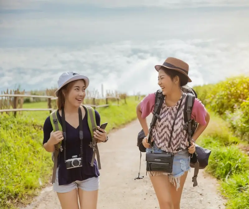 Two backpackers using smartphones with local mobile data while hiking in Indonesia