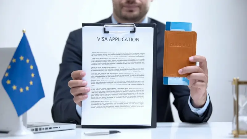Professional immigration consultant holding visa application form and passport with EU flag for European relocation services