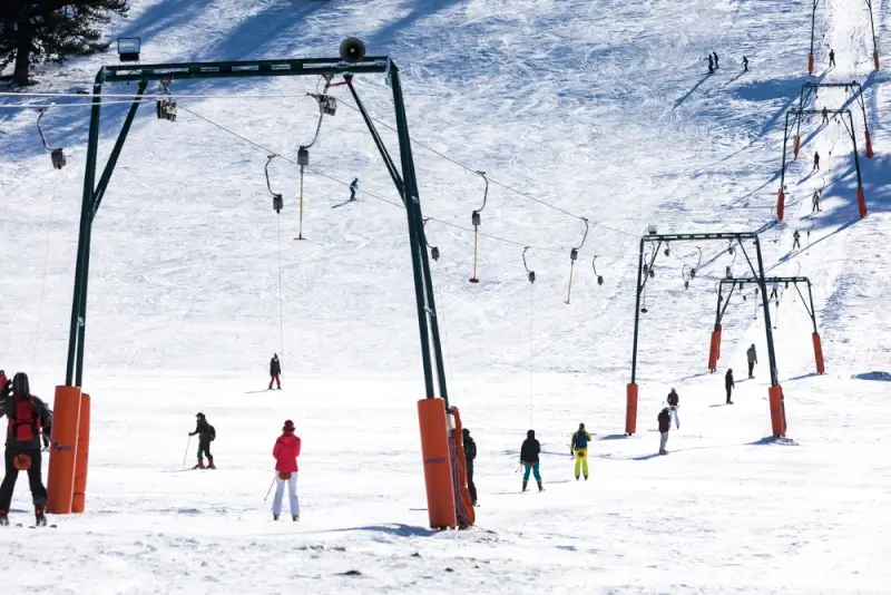 Skiing in Greece at a mountain resort with chairlifts and snow-covered slopes filled with winter sports enthusiasts