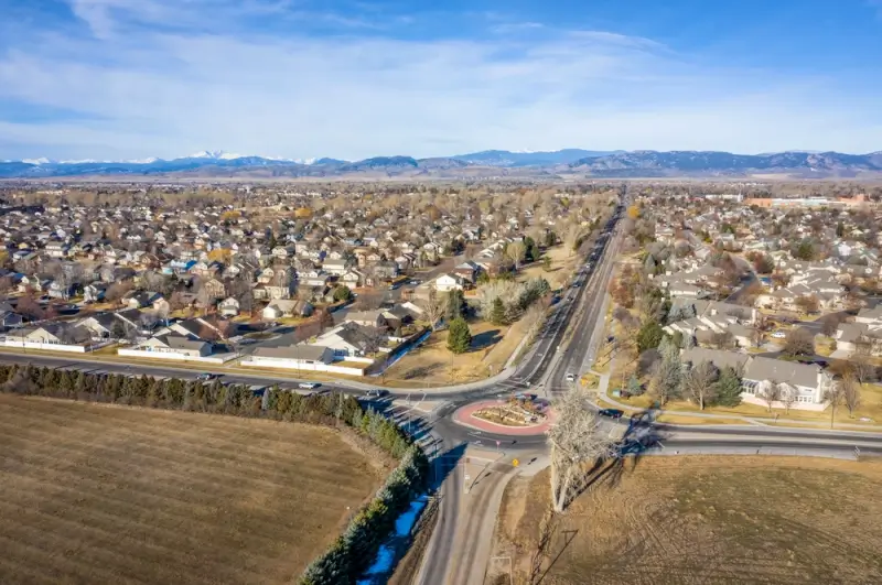 Aerial view of Colorado neighborhood with Rocky Mountain backdrop and suburban homes