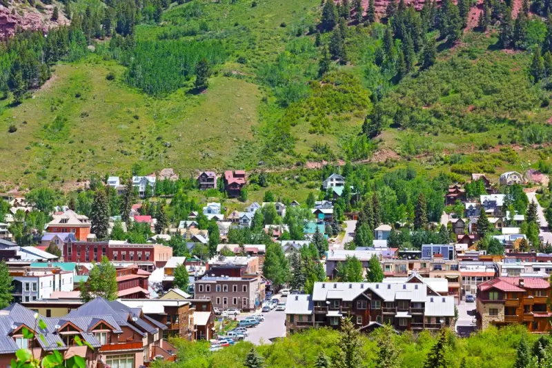 Historic Telluride town nestled in San Juan Mountains with colorful buildings and green hillsides in Colorado