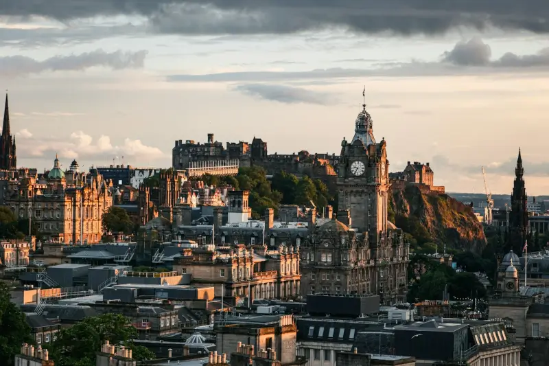 Aerial view of Edinburgh skyline at golden hour with Edinburgh Castle perched on volcanic rock above the city