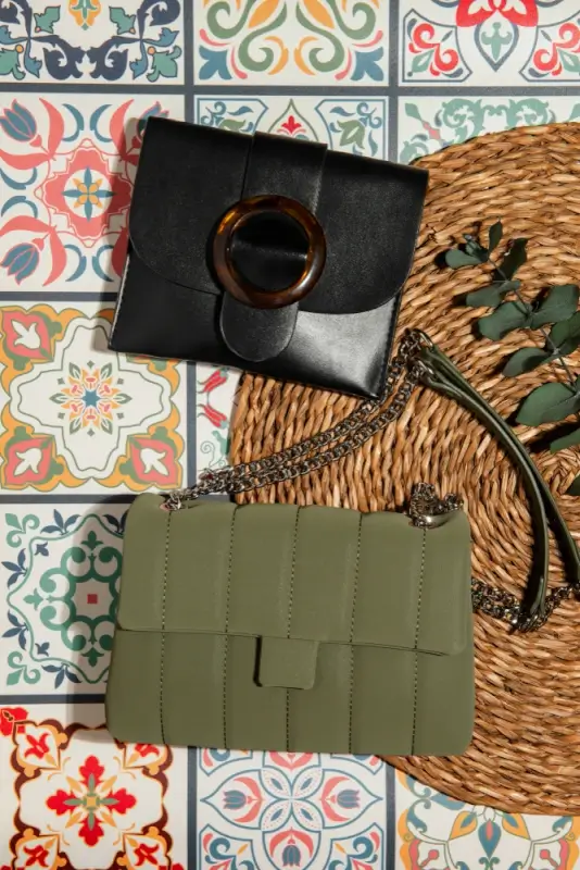 Timeless vintage bags collection featuring classic black clutch with tortoiseshell buckle and olive green quilted crossbody bag styled on colorful Mediterranean tiles