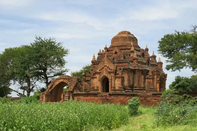 Ancient brick ruins of Dhammayangyi Temple surrounded by greenery in Bagan, Myanmar