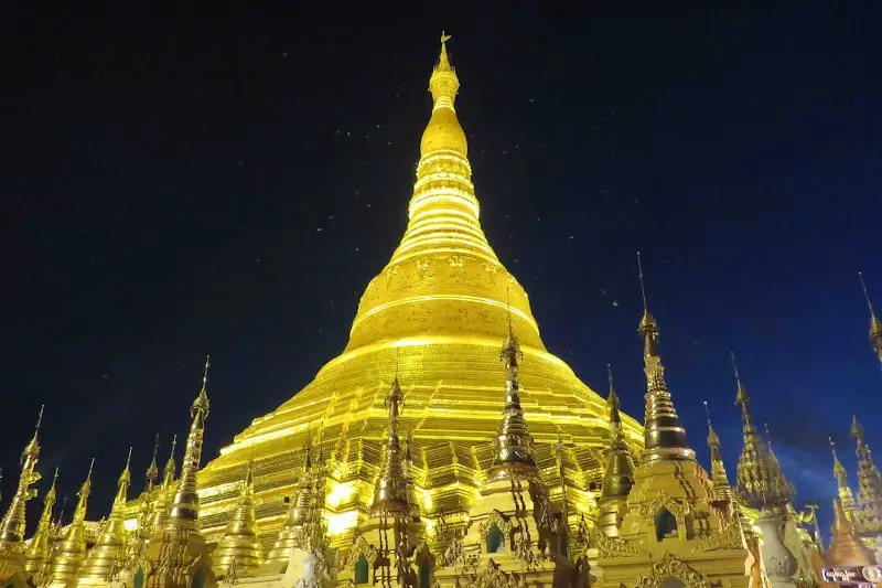 Shwedagon Pagoda glowing golden at night against a dark sky in Yangon, Myanmar