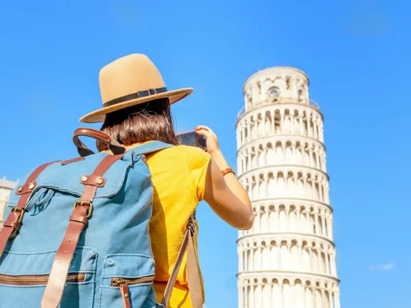Traveler photographing the Leaning Tower of Pisa with smartphone using esim for italy connectivity