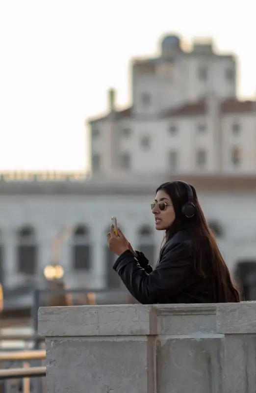 Woman using smartphone with mobile data in Venice Italy while traveling