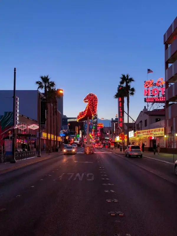Downtown Las Vegas with vintage neon signs and cowboy boot display at dusk