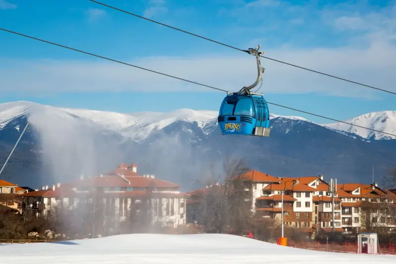 Bansko cable car gondola with snow-capped Pirin Mountains and ski village below in Bulgaria