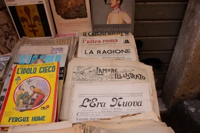 Vintage Italian books and newspapers displayed at an outdoor market stall in Italy