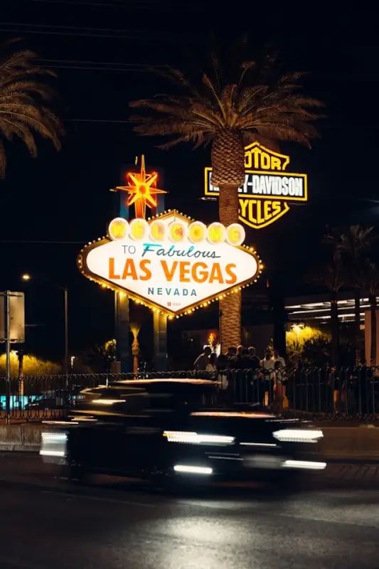 Iconic Welcome to Fabulous Las Vegas sign illuminated at night with palm trees