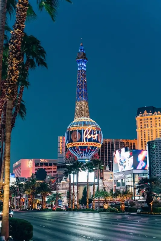 Las Vegas Strip with Paris Hotel Eiffel Tower replica and palm trees at dusk