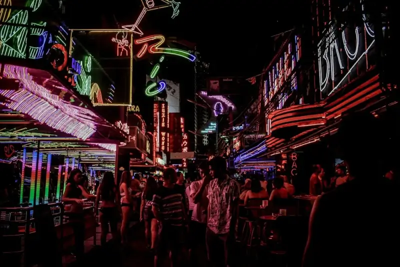 Soi Cowboy nightlife district in Bangkok with colorful neon signs and crowds of travelers