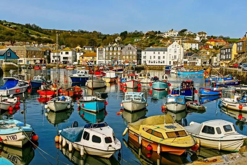 Colourful fishing boats packed in the harbour of Mevagissey, a charming fishing village worth visiting Cornwall for