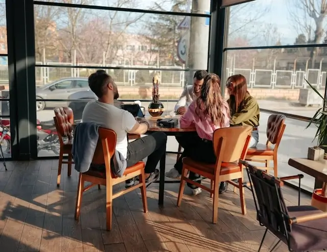 Group of travelers dining together at a sunlit restaurant table